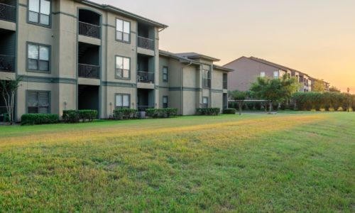 apartment complex in front of a large grassy area
