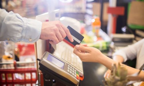 close up of person handing credit card to a cashier