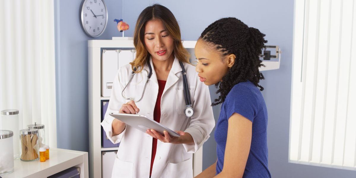 doctor speaking with a patient and pointing to chart